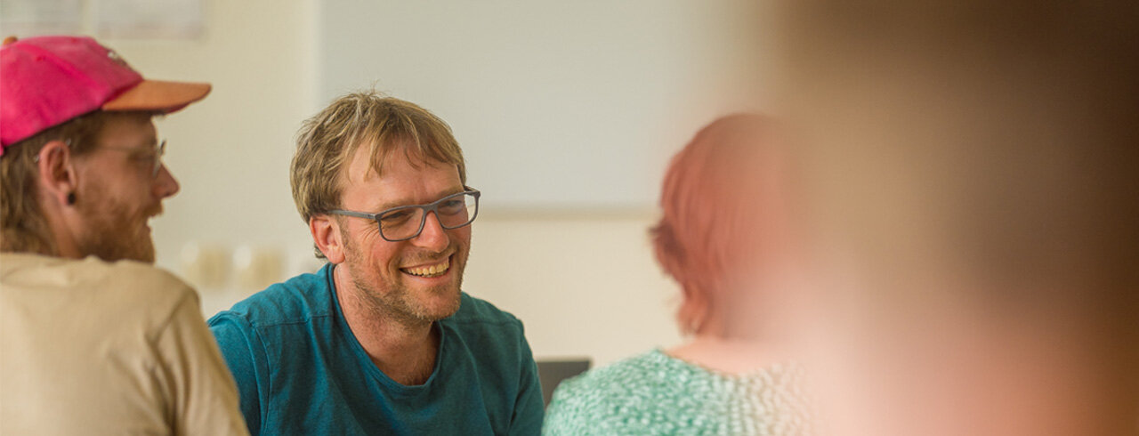 Lehrender im Gespräch mit Studierenden in einer Seminarsituation an der KH Freiburg