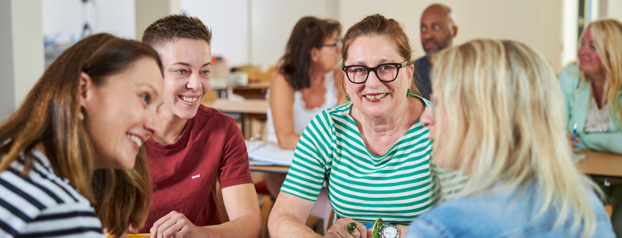 eine Gruppe in einem Seminar im freundlichen Austausch miteinander